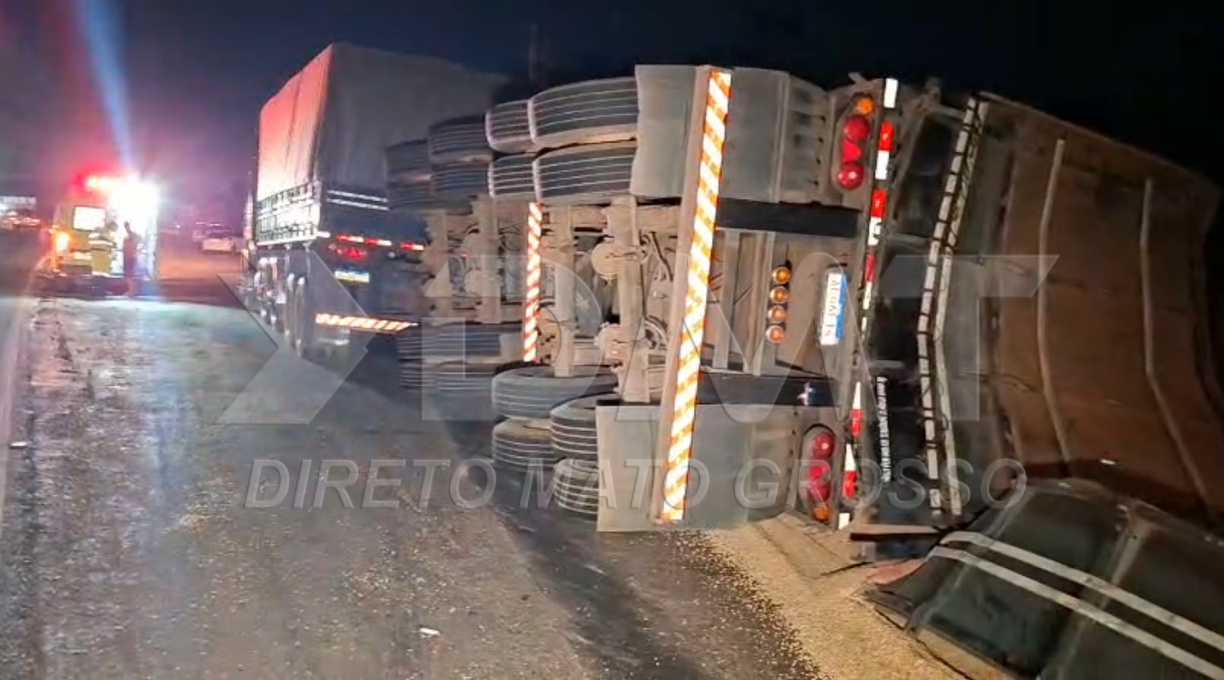 Carreta tomba em rotatória próxima ao 18º GAC, e a carga de soja fica espalhada na via 1