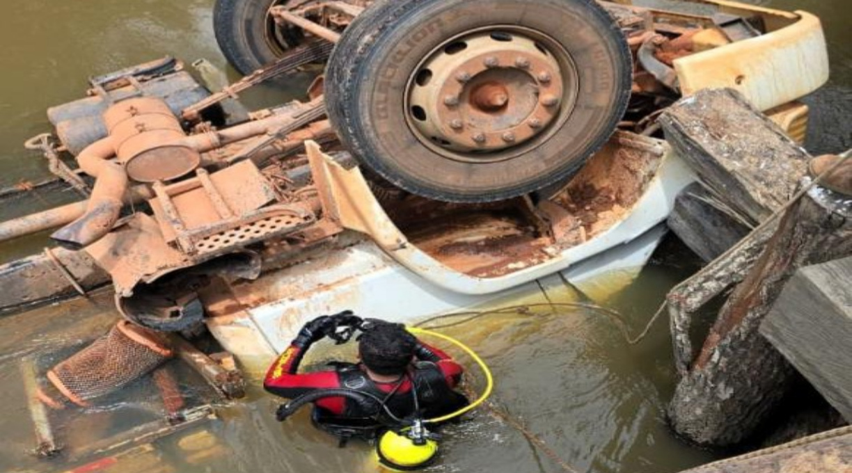 Bombeiros resgatam corpo de vítima presa às ferragens após caminhão tombar e cair em rio 1